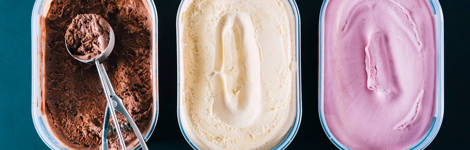 Chocolate, vanilla, and strawberry ice cream in containers.