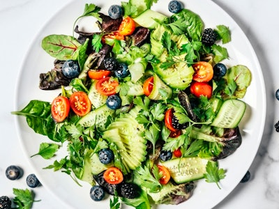 A plate of fresh salad on a white background.