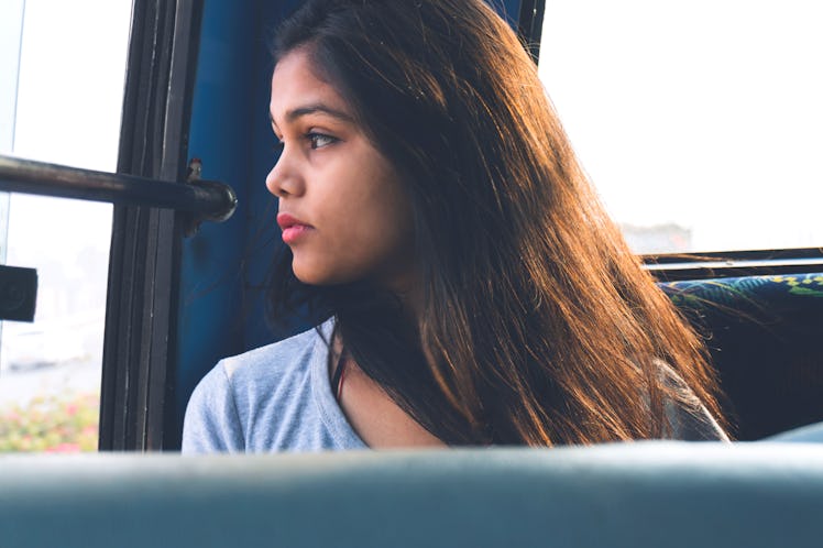 beautiful Asian girl travelling in the bus and sitting near bus window