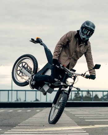 A rider braking and popping up the tail of a Cake Ink SL electric motorcycle