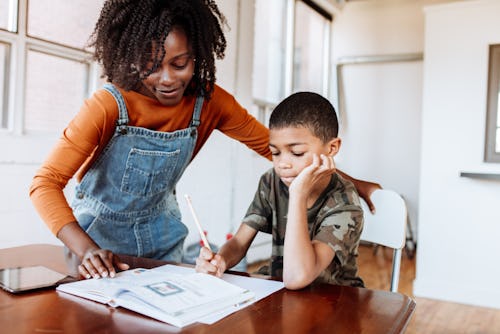 Black mother helping son with homeschooling work