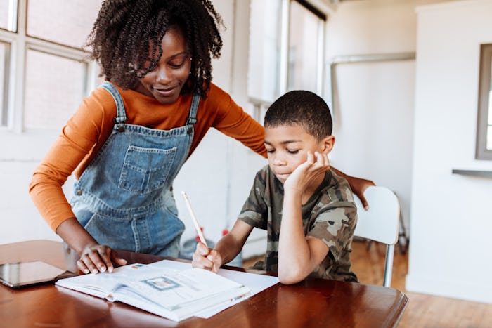 Black mother helping son with homeschooling work