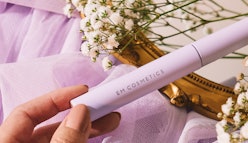 EM Cosmetics' Pick Me Up Mascara in tube, held by hand.
