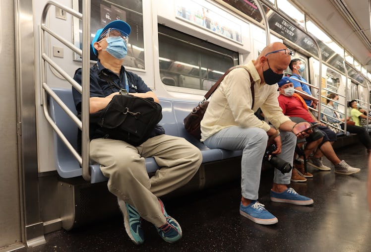 People on the 7 train in NYC wearing masks.