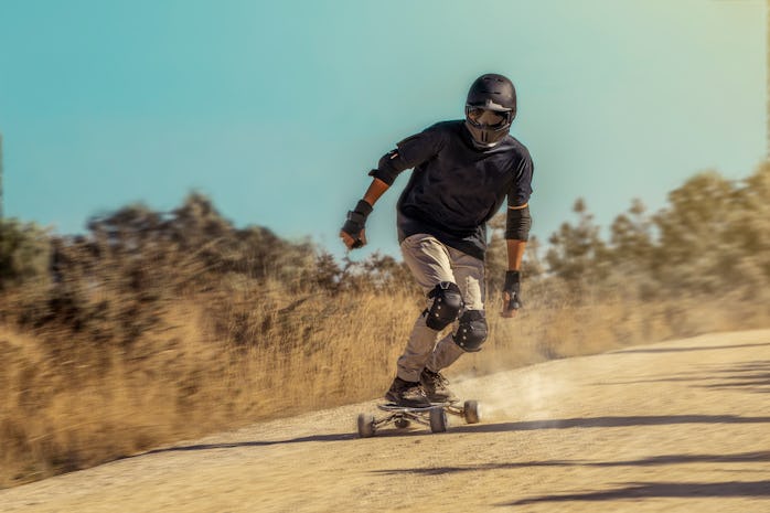A person riding a Hunter Board on a dirt road