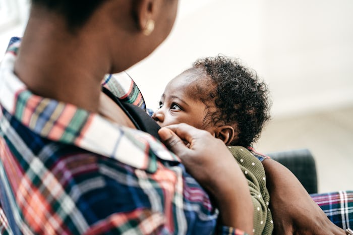 A Black mom breastfeeds her beautiful baby.