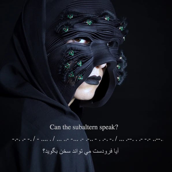 A woman in a deep blue face mask can be seen. The mask has green eyes on it. The text at the bottom ...