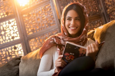 Muslim woman sitting with book