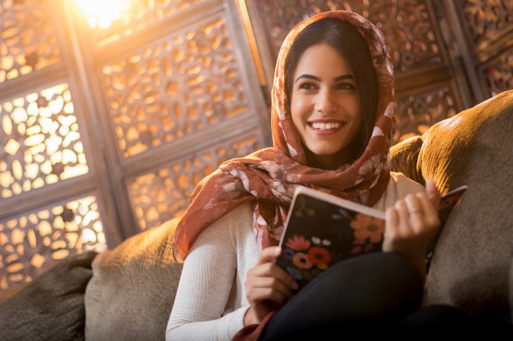 Muslim woman sitting with book