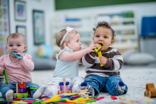 babies playing with each other and toys in a day care setting