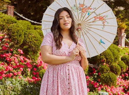 Woman dressed in a cottagecore-style dress with a parasol. 