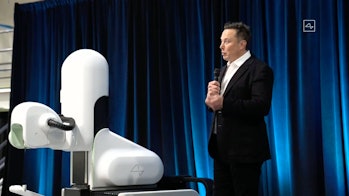 A Neuralink robot surgeon and Elon Musk on stage