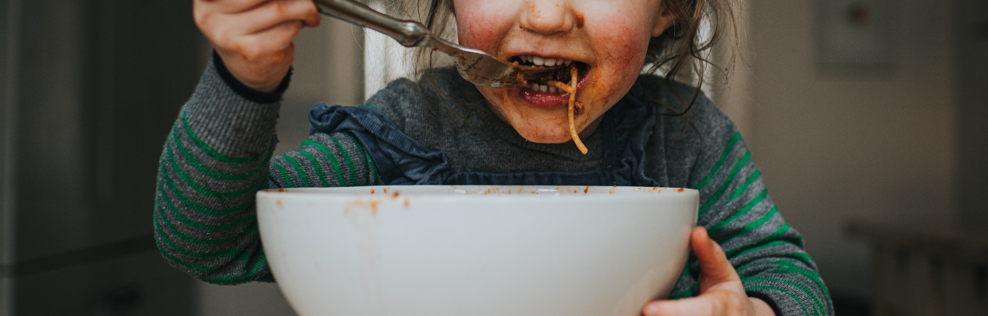 Child eating spaghetti made from slow cooker 
