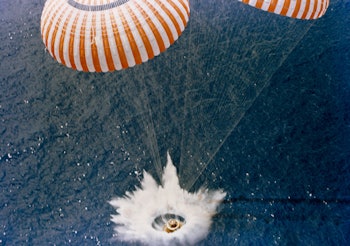 A space shuttle crashing into the ocean with the help of two parachutes