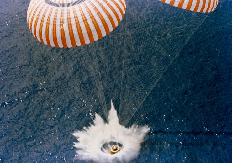 A space shuttle crashing into the ocean with the help of two parachutes