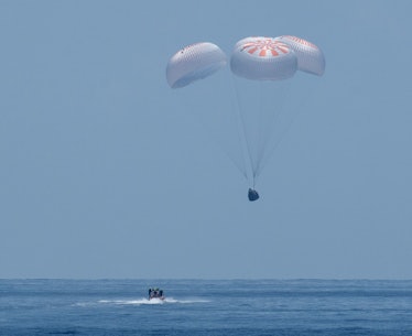 The Crew Dragon capsule returning to Earth.