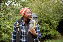 Mercy Shammah in a blue and white checked shirt and backpack in the outdoors