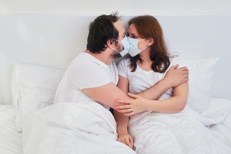 A couple recovering from COVID-19 kissing with their masks on