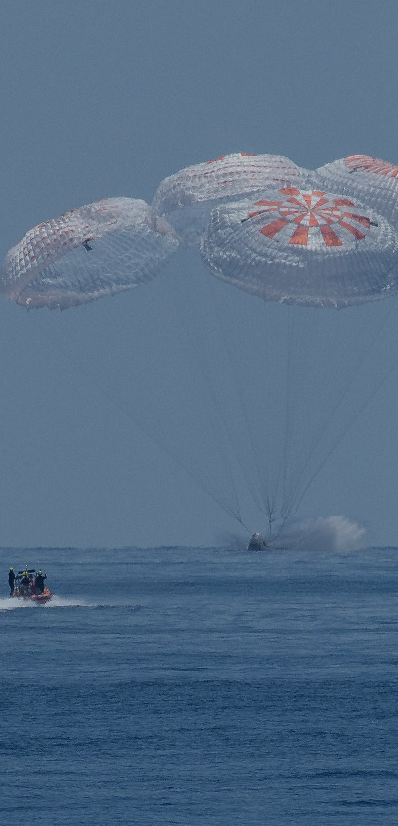 Space X’s Crew Dragon capsule crashing down in the Gulf of Mexico with the help of parachutes