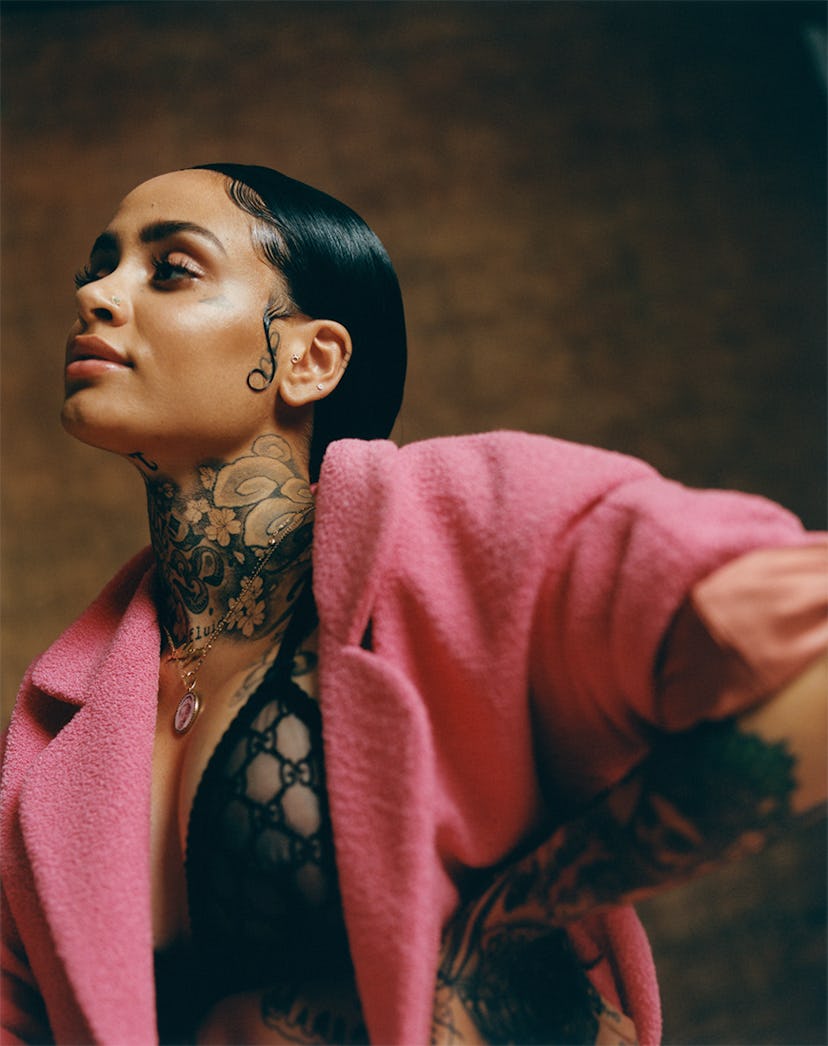 Kehlani posing in a pink top and black bra by Gucci