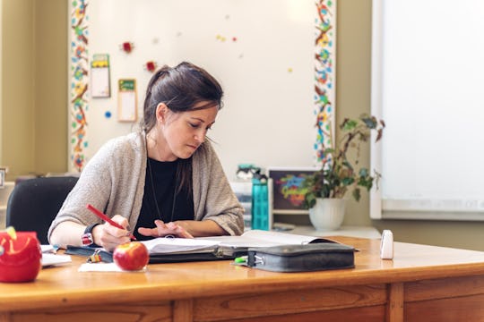 teacher grading papers at her desk