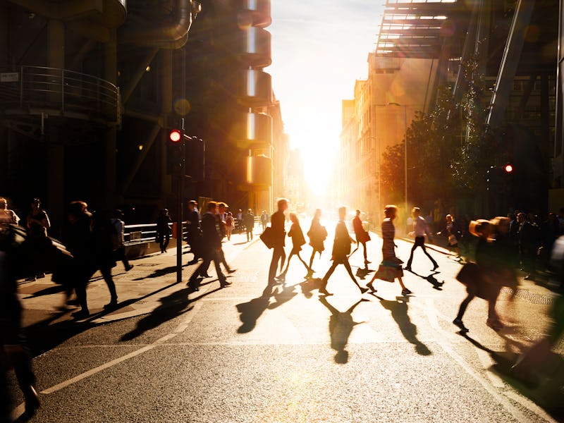 Business people walking through a city at dawn.