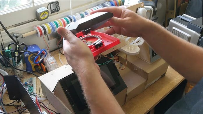 A person's hands working on an automated drink-dispensing machine