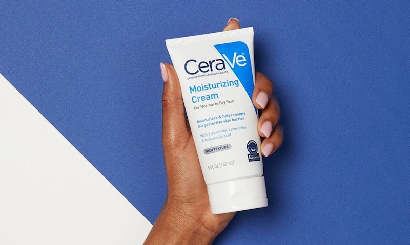 An image of a CeraVe moisturising cream being held up against a blue background with a white triangl...