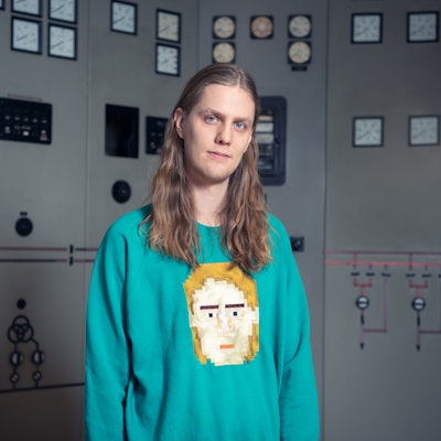Eurovision breakout Daði Freyr in a blue sweatshirt with yellow print, standing and posing