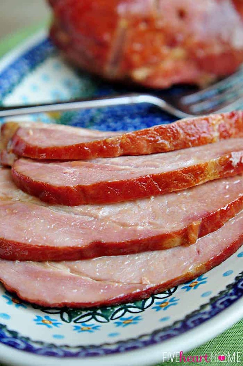 Close up image of brown sugar ham slices on decorative dinner plate