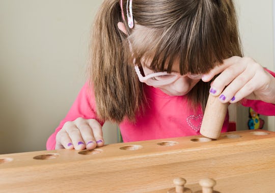 Young girl playing with wooden Montessori blocks