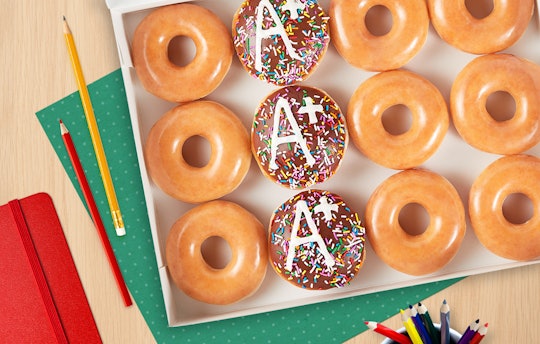 A box of donuts. There are a few plain glazed, a few chocolate filled with an A+ on top, and it's su...