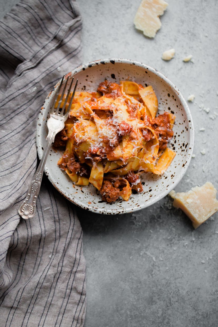 Pasta with slow cooker bolognese sauce served in white dish on grey table