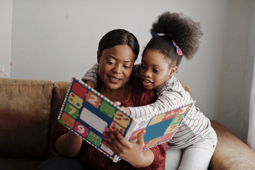 woman reading book to daughter