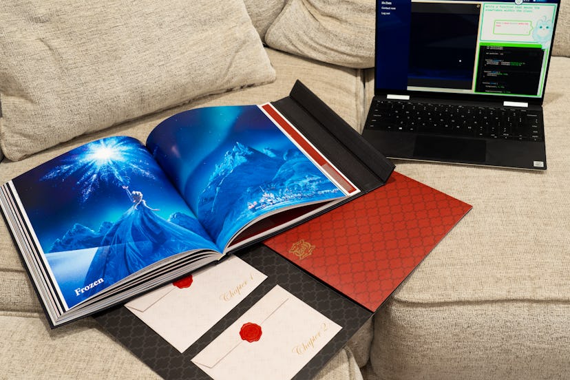 Promotional picture for Disney Codeillusion which features a laptop, the magic book, open to a pictu...