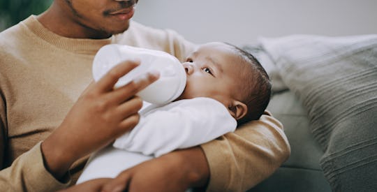 father bottle-feeding baby