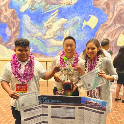 Ku'ualoha Andrade, Dean Capato, and Riki Nishizawa at a science fair who are making sunscreen enviro...