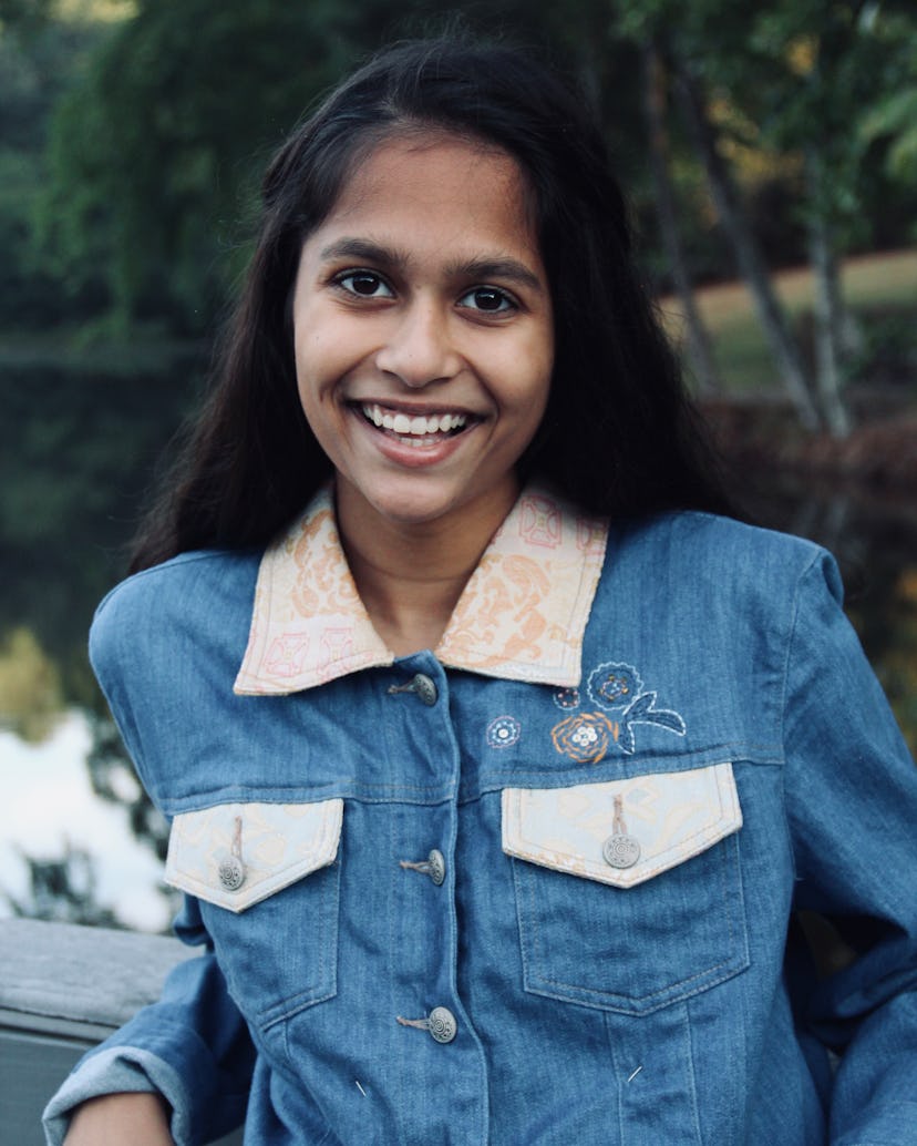 Ritika Sharma in a white and blue denim shirt smiling
