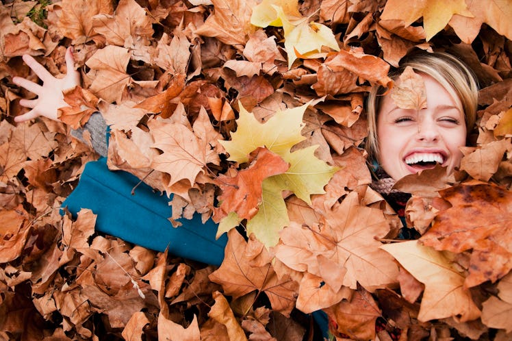 Woman laying in autumn leaves