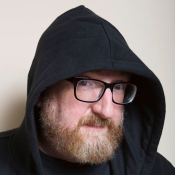Brian Posehn in a black hoodie an black glasses
