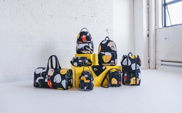 The Herschel x Disney Mickey Mouse collection sits on some yellow blocks in a white loft next to a w...