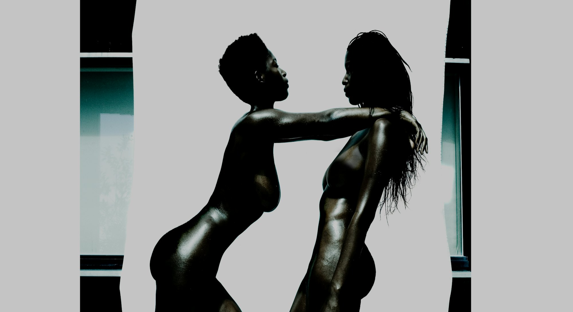 Two naked Black women standing powerfully.