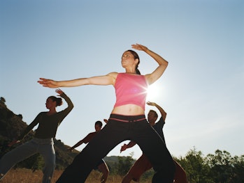 Woman leading group of people in tai-chi position