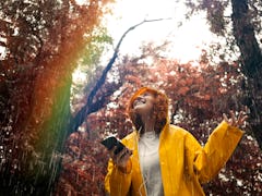 Young woman listening to music in the rain