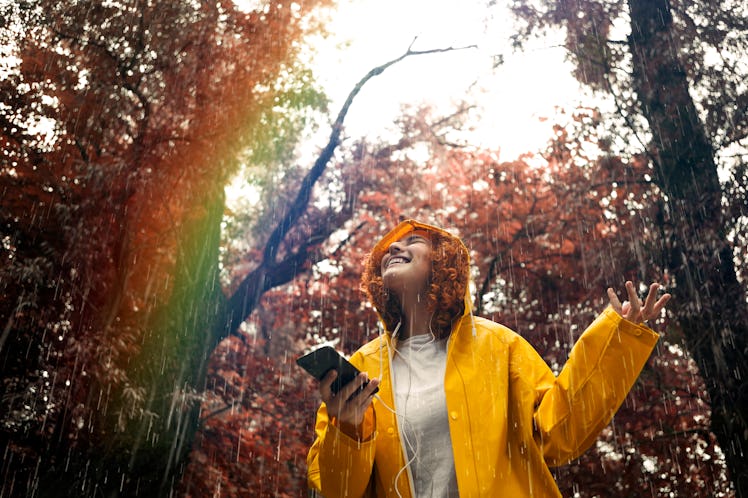 Young woman listening to music in the rain
