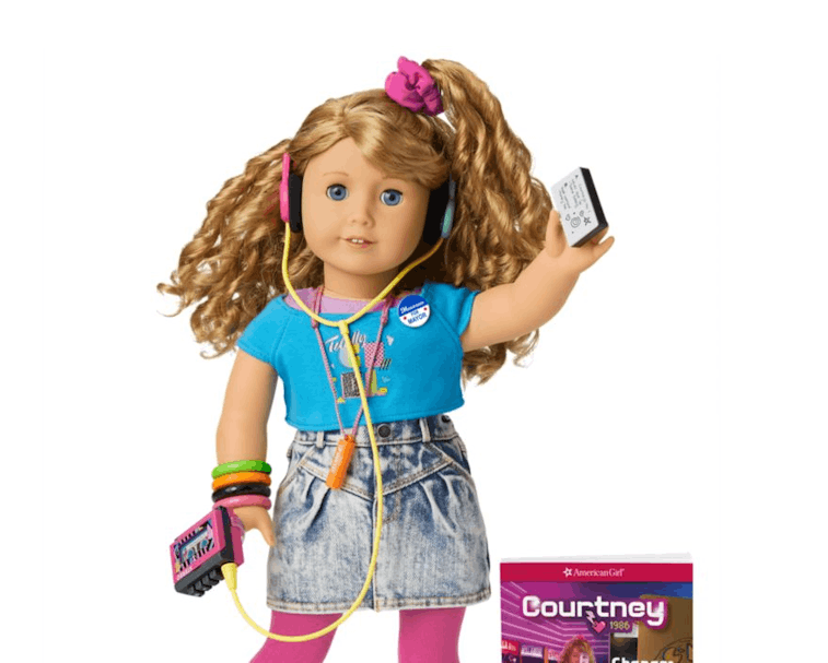 An American Girl named Courtney can be seen with a blue shirt, faded shorts, pink socks, white shoes...