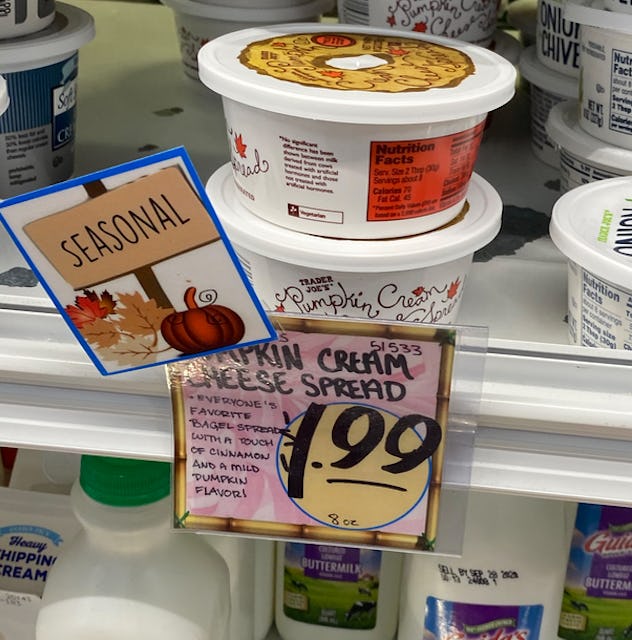 A shelf of pumpkin cream cheese in small tubs. 