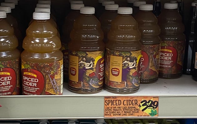 Jars and jars of spiced apple cider on a shelf.
