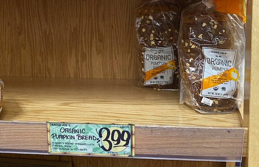 An image of a mostly empty shelf with a few lone loaves of bread. 