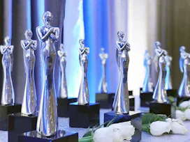 A variety of Mom 2.0 award sculptures in silver and black